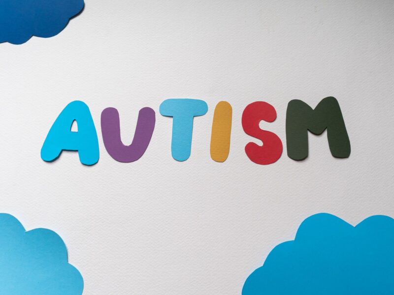 autismo na escola — criança com autismo recebendo apoio de professora em sala de aula inclusiva