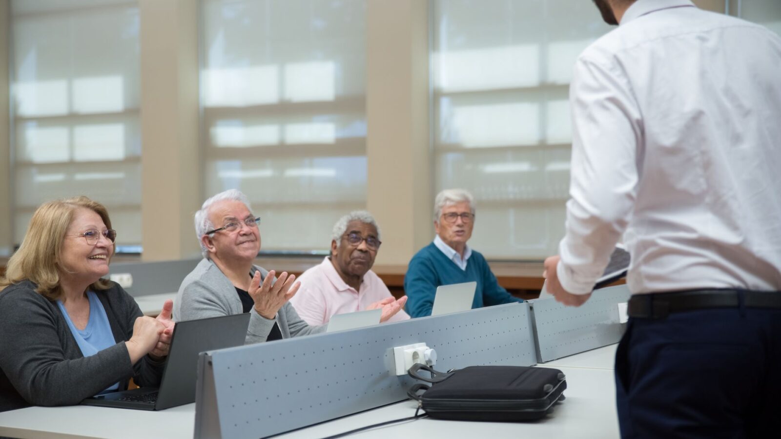 Adultos participando de programa de educação de adultos em sala corporativa