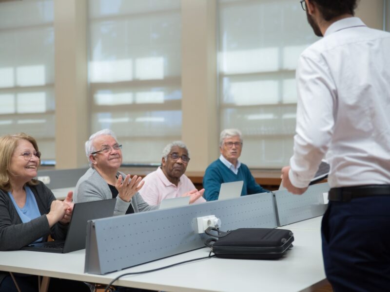 Adultos participando de programa de educação de adultos em sala corporativa