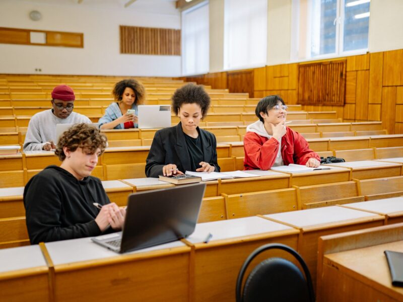 Alunos usando notebook em sala de aula, representando o uso de TIC na educação